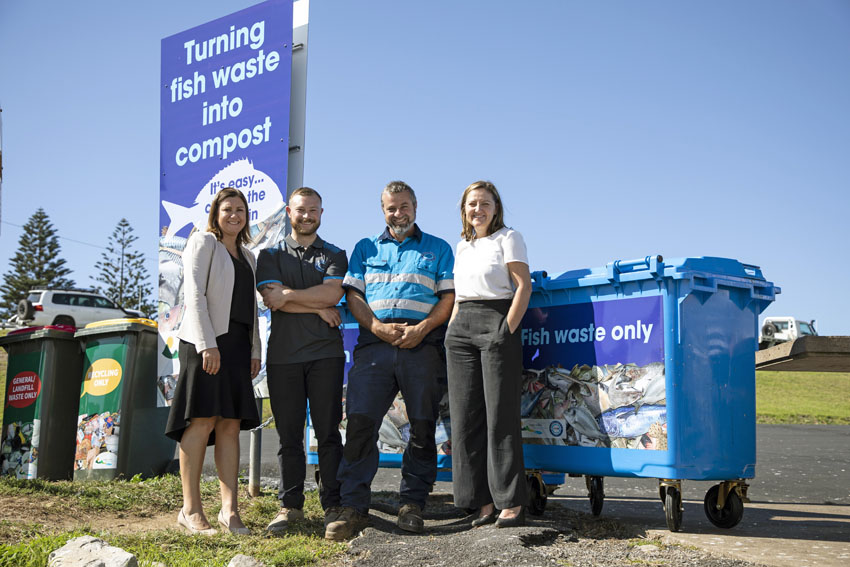 Standing next to one of the blue fish waste bins at Bermagui’s harbour are Bega Valley Shire Mayor Kristy McBain, Ocean2earth founders Kyran and Tim Crane and council’s acting waste services manager Joley Vidau